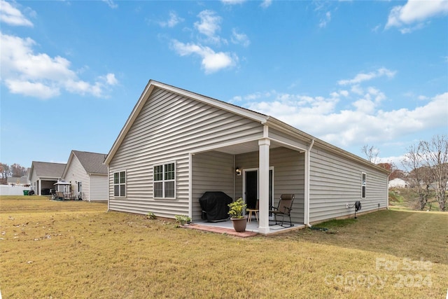 rear view of property featuring a patio area and a yard