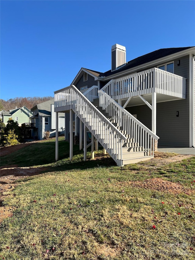 rear view of property with a deck and a lawn