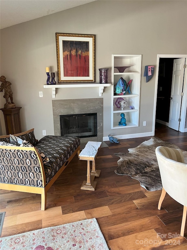 living room with a textured ceiling, a premium fireplace, hardwood / wood-style floors, and lofted ceiling