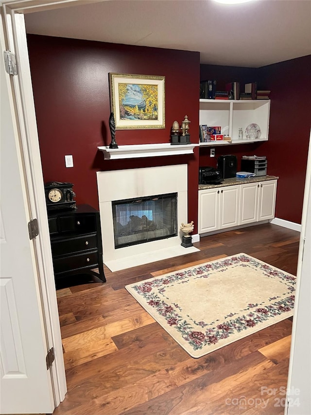 living room featuring a multi sided fireplace and dark wood-type flooring