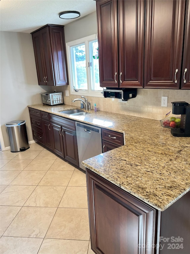 kitchen with decorative backsplash, light stone countertops, sink, and stainless steel dishwasher