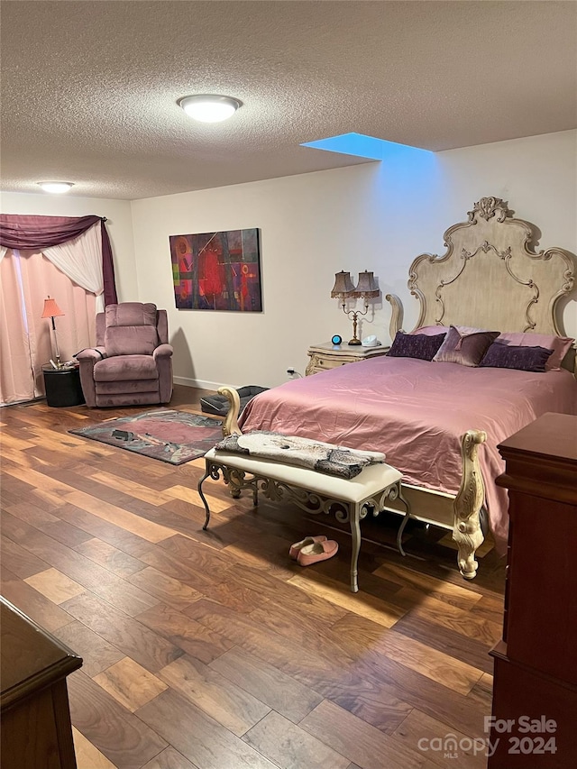 bedroom with hardwood / wood-style flooring and a textured ceiling