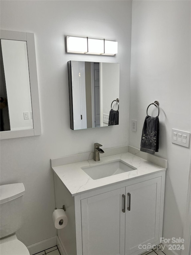 bathroom featuring tile patterned flooring, vanity, and toilet