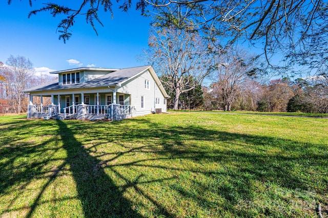 view of side of home with a yard and a porch