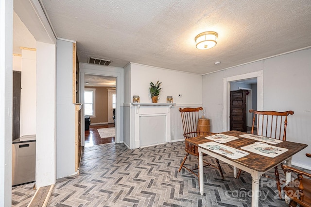 dining area with a textured ceiling and light parquet floors