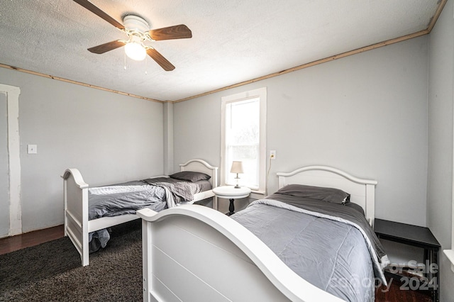 carpeted bedroom with a textured ceiling, ceiling fan, and ornamental molding