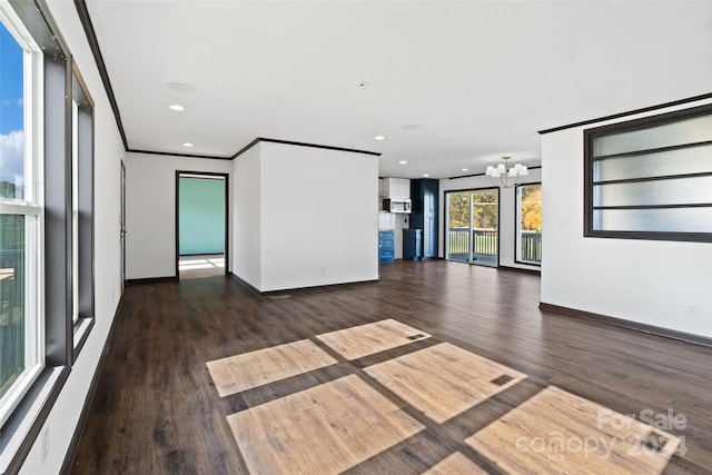 unfurnished living room with dark hardwood / wood-style flooring, crown molding, and a notable chandelier