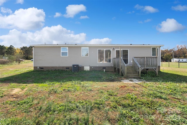 back of house with a deck, a yard, and central air condition unit