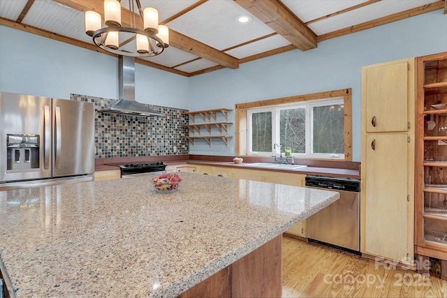 kitchen featuring light stone counters, hanging light fixtures, wall chimney range hood, and stainless steel appliances