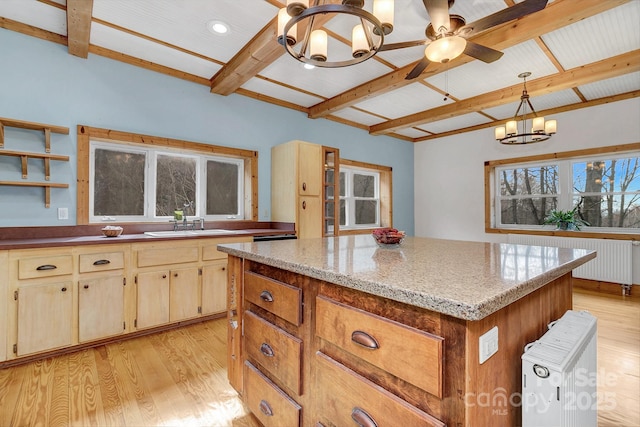 kitchen with sink, radiator, light hardwood / wood-style flooring, an inviting chandelier, and decorative light fixtures