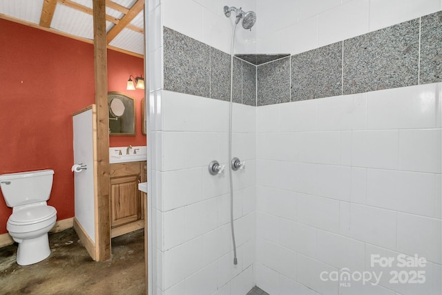 bathroom with vanity, concrete flooring, toilet, and a tile shower