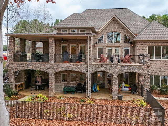 back of property with ceiling fan, a patio area, and a balcony