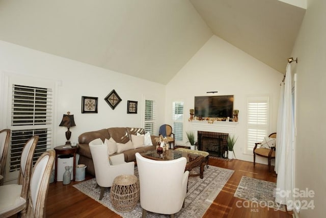 living room with a fireplace, high vaulted ceiling, and dark hardwood / wood-style floors