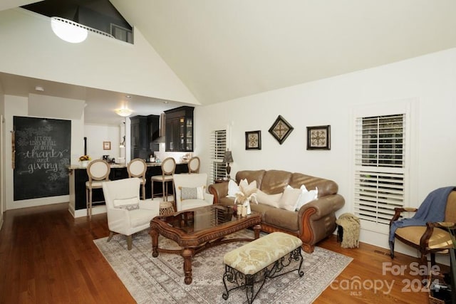 living room with dark hardwood / wood-style floors and high vaulted ceiling