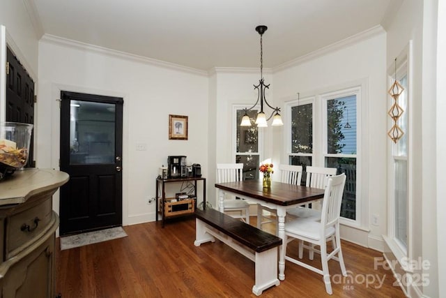 dining room featuring dark wood-style floors, crown molding, and an inviting chandelier