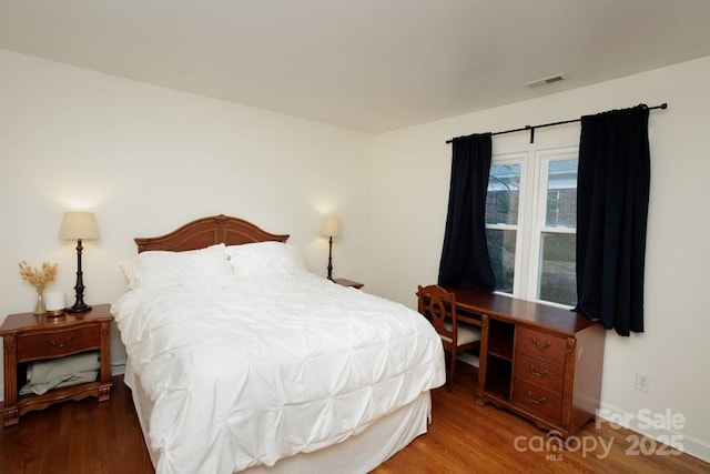 bedroom with visible vents and wood finished floors