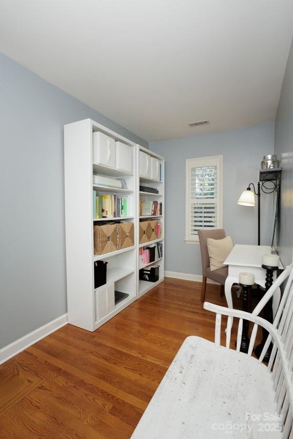 office space with visible vents, baseboards, and wood finished floors