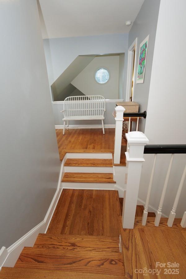 stairs with baseboards and wood finished floors