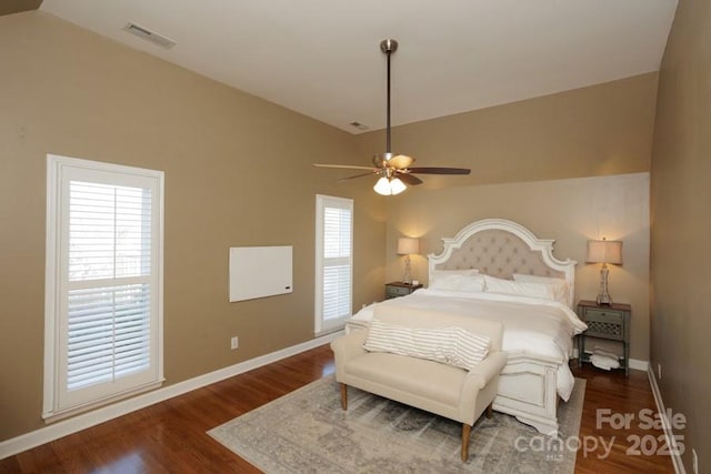 bedroom featuring lofted ceiling, wood finished floors, visible vents, and baseboards