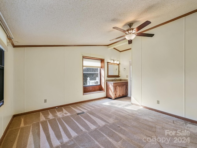 carpeted spare room with sink, crown molding, vaulted ceiling, ceiling fan, and a textured ceiling