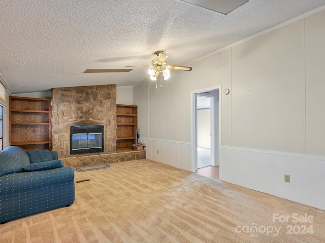 living room featuring light carpet, a stone fireplace, vaulted ceiling, ceiling fan, and a textured ceiling