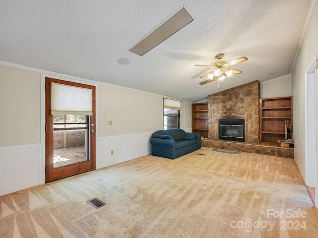 unfurnished living room with lofted ceiling, light carpet, ceiling fan, a fireplace, and a textured ceiling