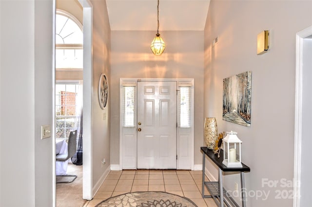 tiled foyer entrance with a towering ceiling