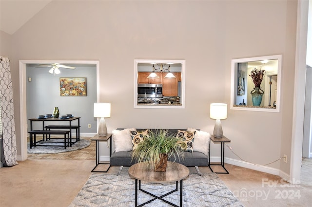 carpeted living room with high vaulted ceiling and ceiling fan