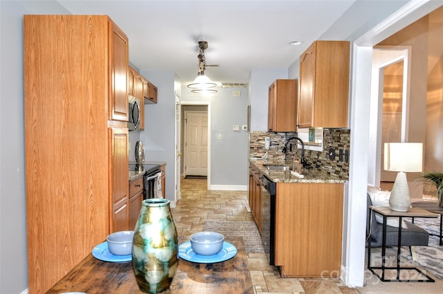 kitchen featuring light stone countertops, appliances with stainless steel finishes, tasteful backsplash, sink, and pendant lighting