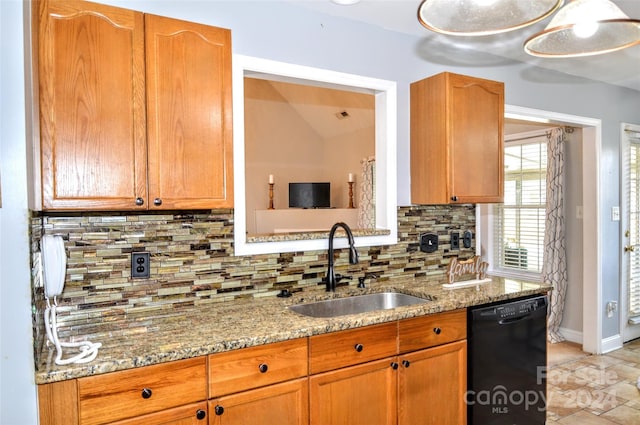 kitchen featuring light stone countertops, sink, and black dishwasher