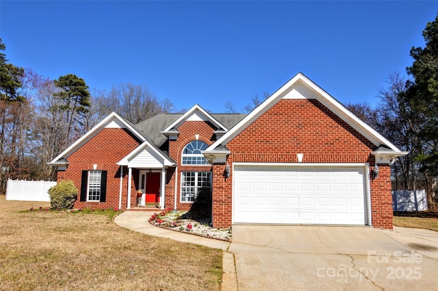 traditional-style home featuring driveway, an attached garage, fence, a front lawn, and brick siding