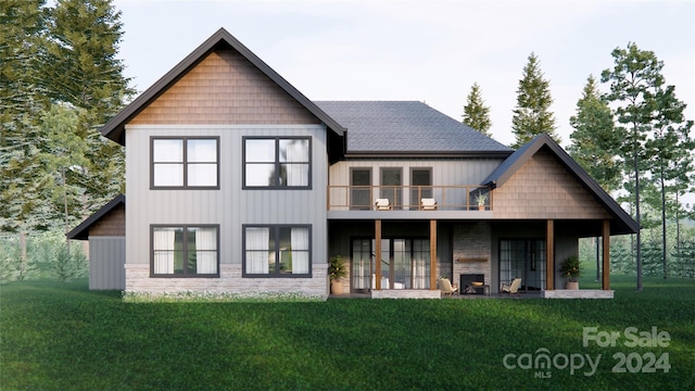 rear view of property with a yard and a balcony