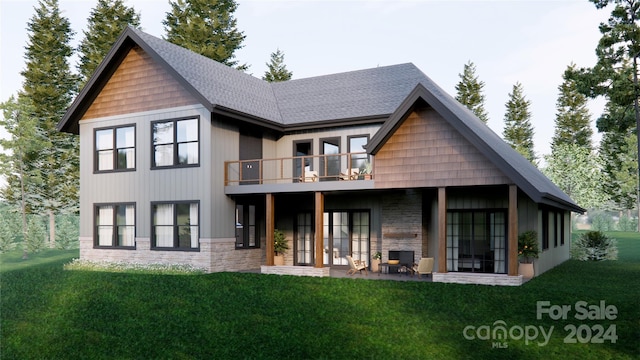 rear view of house featuring a balcony, a yard, and a patio