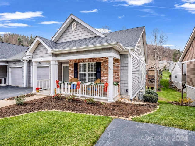 view of front of house with a porch, a garage, and a front yard