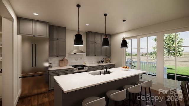 kitchen featuring decorative backsplash, dark hardwood / wood-style flooring, sink, high quality appliances, and an island with sink