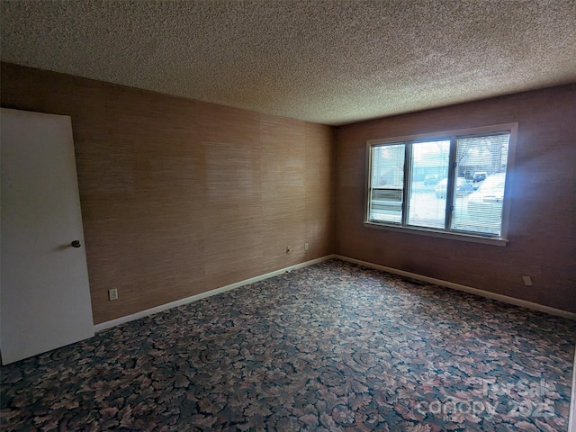 carpeted spare room featuring a textured ceiling