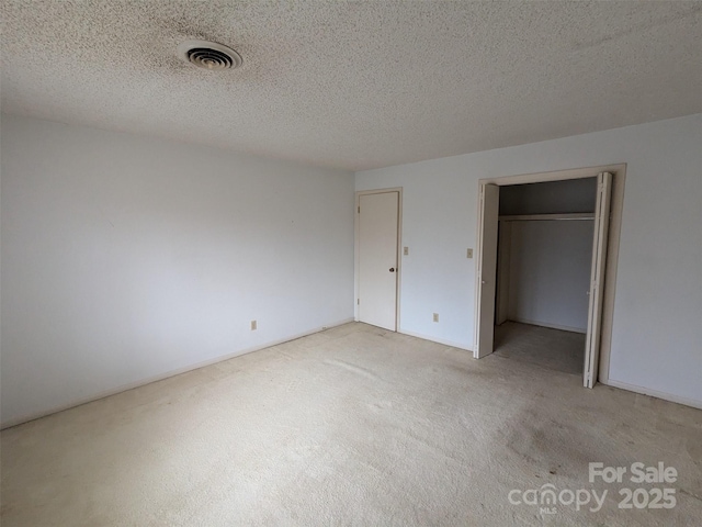 unfurnished bedroom featuring light colored carpet and a textured ceiling