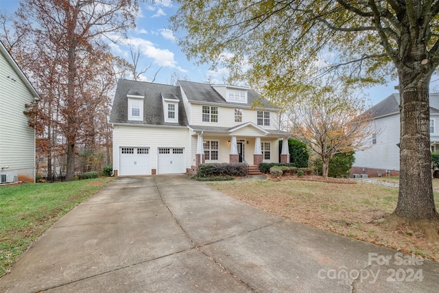 view of front of home with a porch, a garage, and a front lawn