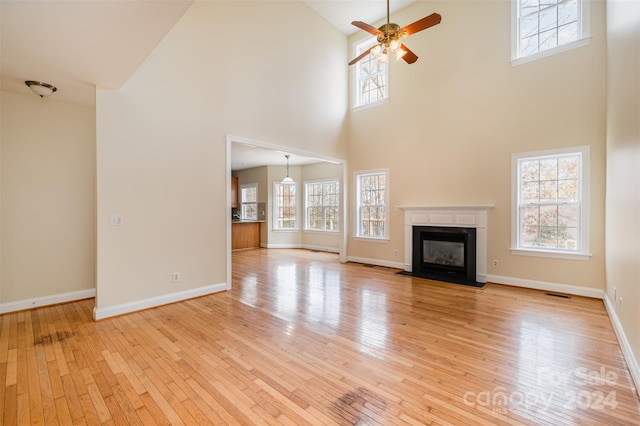 unfurnished living room featuring ceiling fan, high vaulted ceiling, and light hardwood / wood-style floors