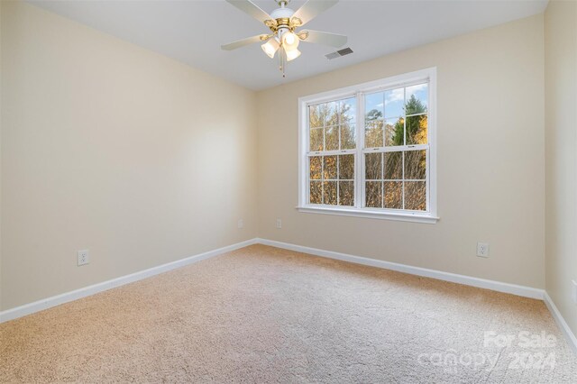 carpeted empty room featuring ceiling fan