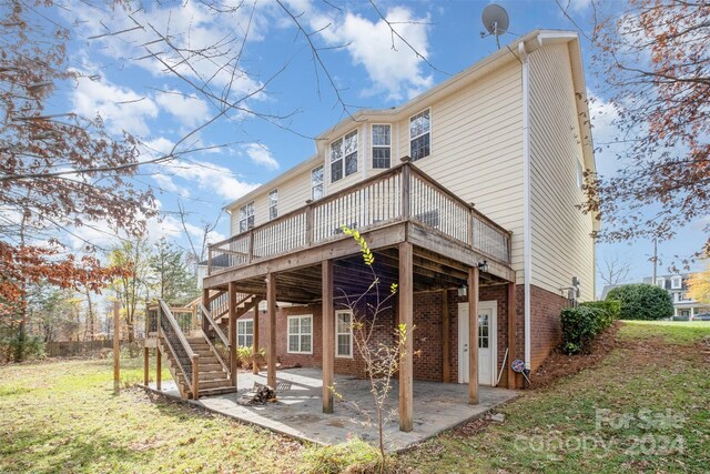 rear view of house featuring a lawn, a patio area, and a wooden deck