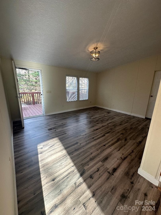 unfurnished room featuring dark hardwood / wood-style floors and a textured ceiling