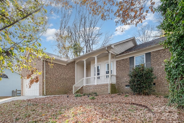 single story home featuring a porch and a garage