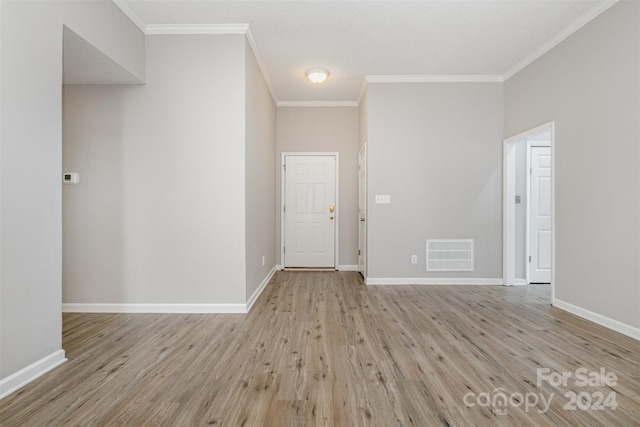 empty room featuring crown molding and light hardwood / wood-style flooring