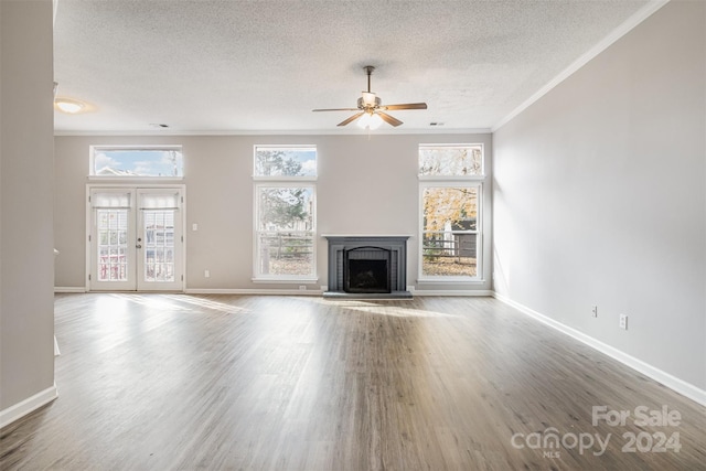 unfurnished living room with a wealth of natural light, french doors, and hardwood / wood-style flooring