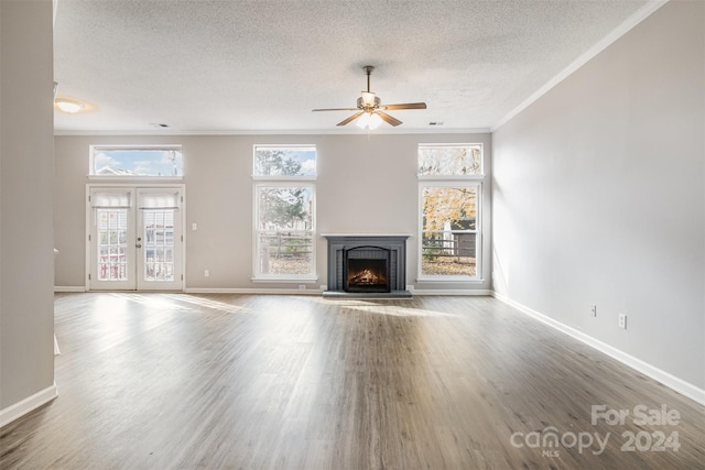 unfurnished living room featuring wood-type flooring, french doors, and a healthy amount of sunlight