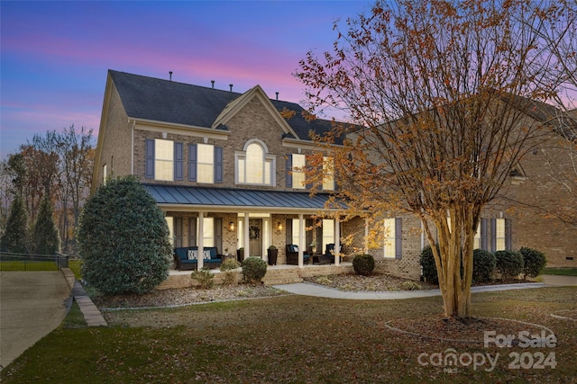 view of front of property with a lawn and a porch