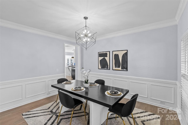 dining room featuring crown molding, hardwood / wood-style floors, and a chandelier