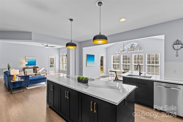 kitchen with stainless steel dishwasher, ceiling fan with notable chandelier, sink, decorative light fixtures, and a center island