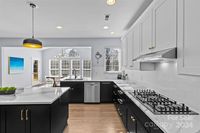 kitchen with white cabinetry, sink, gas stovetop, light hardwood / wood-style floors, and decorative light fixtures